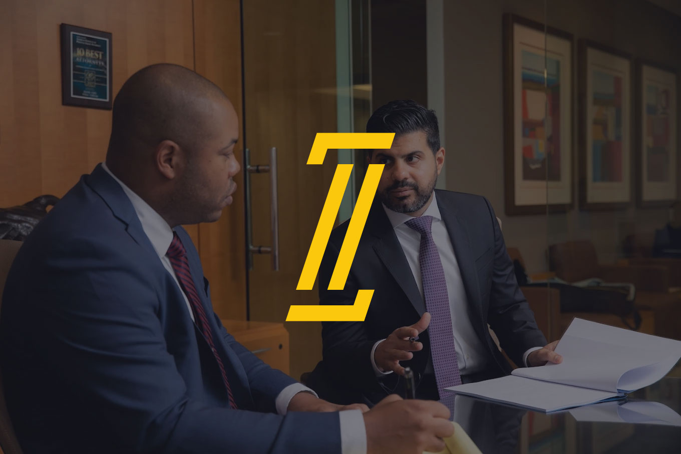 ZIPI Law attorneys in consultation with the gold column mark